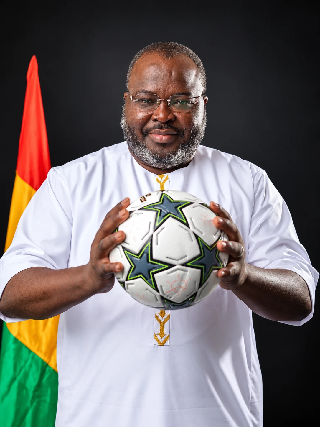 Le Dr Ibrahima Khalil KABA tend un ballon, devant le drapeau guinéen